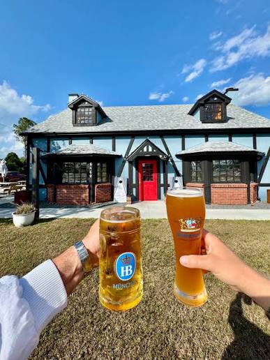 Two beer glasses raised in a cheers outside the cottage